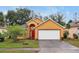 Nice curb appeal! Yellow house with red accents and a two-car garage at 7872 Niagara Falls Ct, Orlando, FL 32825