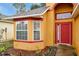 Front entrance with a red door and a bay window at 7872 Niagara Falls Ct, Orlando, FL 32825