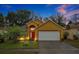 Attractive yellow house with a red door and white garage door at 7872 Niagara Falls Ct, Orlando, FL 32825