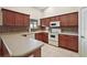 Spacious kitchen with dark wood cabinets, tile backsplash, and ample counter space at 791 Princeton Dr, Clermont, FL 34711