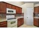 Kitchen features white appliances and dark wood cabinets at 791 Princeton Dr, Clermont, FL 34711