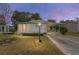 Mobile home at dusk with a landscaped yard and driveway at 807 Maple Ln, The Villages, FL 32159