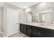 Double vanity bathroom with dark cabinets and a large mirror at 848 Carmillion Ct, Groveland, FL 34736