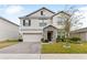 Two-story house with a large driveway and landscaped lawn at 848 Carmillion Ct, Groveland, FL 34736