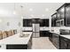 Modern kitchen with dark cabinets, stainless steel appliances, and a large island at 848 Carmillion Ct, Groveland, FL 34736