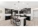 Modern kitchen with dark cabinets, stainless steel appliances, and a large island at 848 Carmillion Ct, Groveland, FL 34736