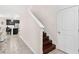 Modern staircase with dark wood treads and white railing, view of kitchen at 848 Carmillion Ct, Groveland, FL 34736