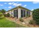 Enclosed sunroom and landscaped yard with gravel pathway at 848 Folsum Pl, The Villages, FL 32162