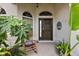 Inviting front entry with rocking chair and lush tropical plants at 848 Folsum Pl, The Villages, FL 32162