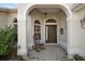 Inviting front porch with rocking chair and arched entryway at 848 Folsum Pl, The Villages, FL 32162