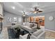 Virtually staged living room, open to kitchen, with tile floors and ceiling fans at 9605 Hollyglen Pl, Windermere, FL 34786