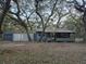 Cozy one-story house with covered porch and detached garage, nestled among mature trees at 10094 Sw 153Rd Ln, Dunnellon, FL 34432