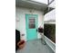 Exterior back door with teal paint and hose reel at 1017 Willow Dr, Leesburg, FL 34748