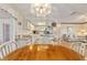 Dining room features a wooden table, white chairs and view of kitchen at 10476 Se 178Th St, Summerfield, FL 34491