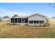 Rear view of house with screened porch and yard at 10476 Se 178Th St, Summerfield, FL 34491