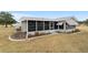 Rear view of house with screened porch and yard at 10476 Se 178Th St, Summerfield, FL 34491