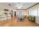 Bright living room with floral sofa, wood floors, and a view to the kitchen at 10476 Se 178Th St, Summerfield, FL 34491
