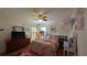 Bedroom with wood floors, ceiling fan and dresser at 12288 Ne 48Th Loop, Oxford, FL 34484