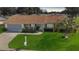 Single-story home with a brown roof, attached garage, and landscaped lawn at 13709 Se 89Th Ave, Summerfield, FL 34491