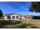 Back of house showing yard, patio, and mature trees at 13709 Se 89Th Ave, Summerfield, FL 34491