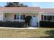 Front entrance of a single-story house with a covered porch and red shutters at 13709 Se 89Th Ave, Summerfield, FL 34491