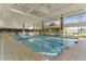 Resort-style indoor swimming pool with large windows and natural light at 13709 Se 89Th Ave, Summerfield, FL 34491