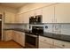 Updated kitchen with stainless steel appliances and dark countertops at 13709 Se 89Th Ave, Summerfield, FL 34491