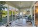 Bright sunroom with white sliding glass doors, tile floors, and wicker furniture at 1418 Mccoll Ct, The Villages, FL 32162