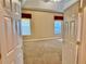 Spacious bedroom with carpeted floors and two windows with red valances at 1515 Gadsden Pl, The Villages, FL 32162