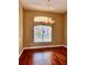 Formal dining room with hardwood flooring, traditional chandelier, and large bright window at 1515 Gadsden Pl, The Villages, FL 32162