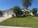 Charming single-story home featuring a well-manicured lawn, attached garage, and inviting landscaping at 1515 Gadsden Pl, The Villages, FL 32162