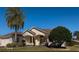 House exterior features a landscaped yard and palm trees at 1515 Gadsden Pl, The Villages, FL 32162