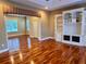 Open-concept living room with hardwood floors, built-in shelving, and an adjacent room at 1515 Gadsden Pl, The Villages, FL 32162