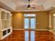 Spacious living room with hardwood floors, french doors, and built-in shelving at 1515 Gadsden Pl, The Villages, FL 32162