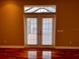 Living room with hardwood floors and double doors leading to a patio at 1515 Gadsden Pl, The Villages, FL 32162