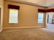 Large main bedroom with carpeted floor, two windows, and red valances at 1515 Gadsden Pl, The Villages, FL 32162