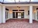 Covered outdoor patio with brick flooring, ceiling fan, and view into the living area at 1515 Gadsden Pl, The Villages, FL 32162