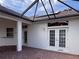 Covered patio with brick pavers, featuring French doors and a covered area at 1515 Gadsden Pl, The Villages, FL 32162