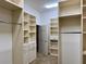 Large walk-in closet with custom shelving, drawers, and ample storage space at 1515 Gadsden Pl, The Villages, FL 32162