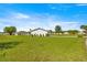Wide backyard with lush green grass, small hedges, and plenty of room for outdoor activities at 17664 Se 105Th Terrace, Summerfield, FL 34491
