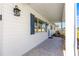 Covered porch featuring a patterned floor, white siding, and a welcoming entrance to the house at 17664 Se 105Th Terrace, Summerfield, FL 34491