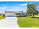 Charming single-story home features a well-manicured lawn and a concrete driveway leading to an attached two-car garage at 17664 Se 105Th Terrace, Summerfield, FL 34491