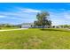 Landscaped front yard showcasing the home with a well-manicured lawn and a beautiful mature tree at 17664 Se 105Th Terrace, Summerfield, FL 34491