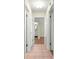 Hallway with tile flooring, leading to a bathroom and rooms with wood floors at 17664 Se 105Th Terrace, Summerfield, FL 34491