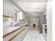 Functional kitchen with white cabinetry, stainless steel refrigerator, tile flooring, and ample counter space for meal prep at 17664 Se 105Th Terrace, Summerfield, FL 34491