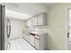 Well-lit kitchen with white cabinets, stainless steel appliances, and tile flooring, offering a clean and practical cooking space at 17664 Se 105Th Terrace, Summerfield, FL 34491