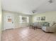 Inviting living room with natural light, comfortable seating, neutral tones, tiled flooring, and a welcoming atmosphere at 17664 Se 105Th Terrace, Summerfield, FL 34491