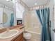 Bathroom with tub, shower, and blue patterned curtains at 2005 Palo Alto Ave, The Villages, FL 32159