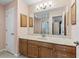 Bathroom with wood cabinets, marble countertop, and a shower at 2005 Palo Alto Ave, The Villages, FL 32159