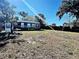 Large backyard with a small dark blue house at 248 E Magnolia St, Groveland, FL 34736